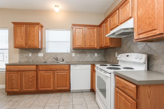 24006 Lestergate Dr, Spring, TX 77373 - kitchen with a sink, white appliances, under cabinet range hood, decorative backsplash, and light tile patterned floors