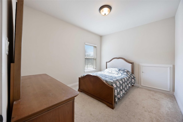 bedroom with light colored carpet and baseboards