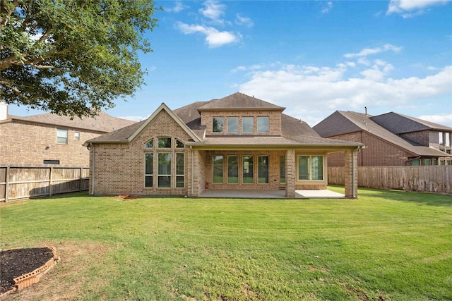 back of property featuring a yard, a patio area, and brick siding
