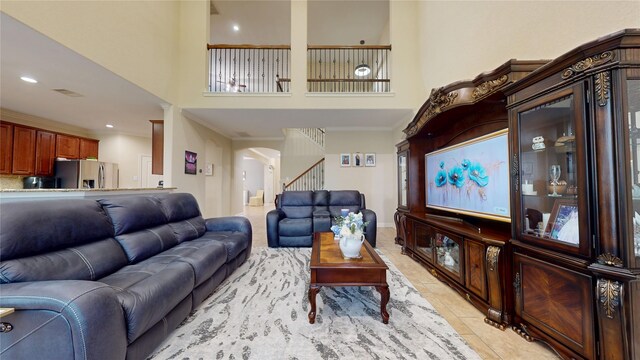 18818 Bene Vista Dr, Houston, TX 77084 - living area with stairs, decorative columns, a towering ceiling, crown molding, and light tile patterned floors