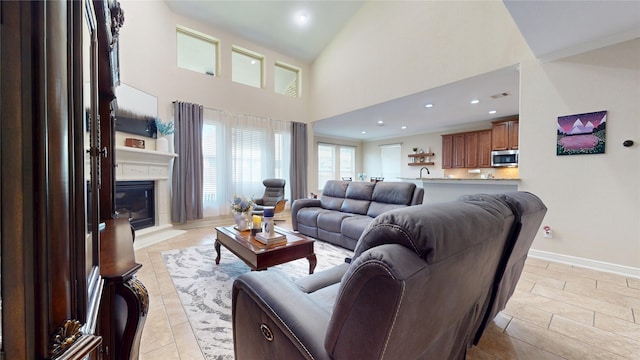 18818 Bene Vista Dr, Houston, TX 77084 - living area featuring recessed lighting, baseboards, light tile patterned floors, a glass covered fireplace, and a towering ceiling