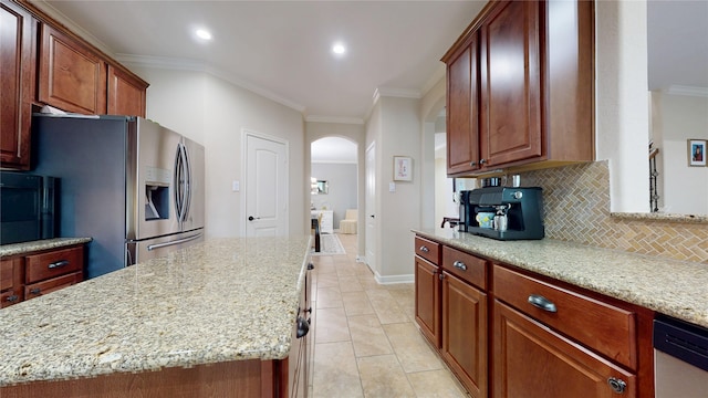 18818 Bene Vista Dr, Houston, TX 77084 - kitchen featuring ornamental molding, backsplash, arched walkways, a kitchen island, and appliances with stainless steel finishes