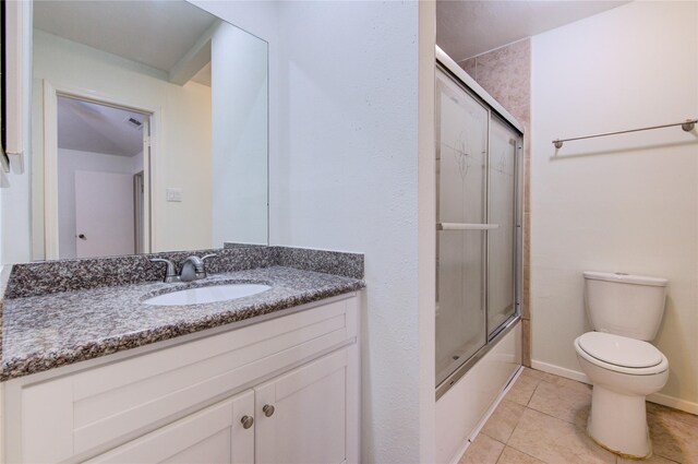 2215 Squire Dobbins Dr, Sugar Land, TX 77478 - full bathroom with toilet, tile patterned flooring, vanity, combined bath / shower with glass door, and baseboards