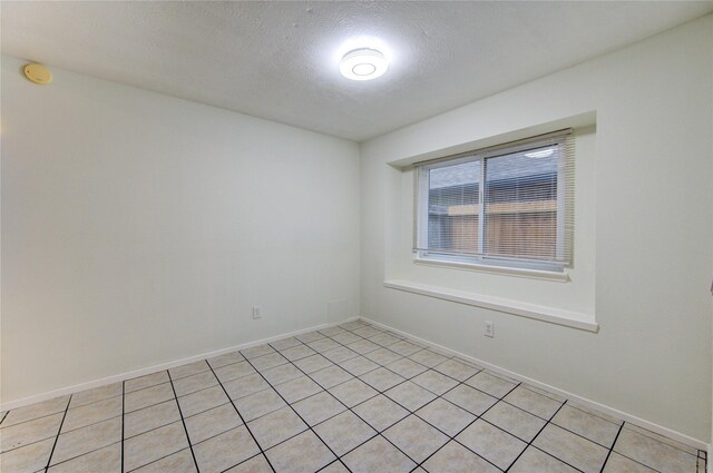 2215 Squire Dobbins Dr, Sugar Land, TX 77478 - spare room featuring a textured ceiling, baseboards, and light tile patterned floors