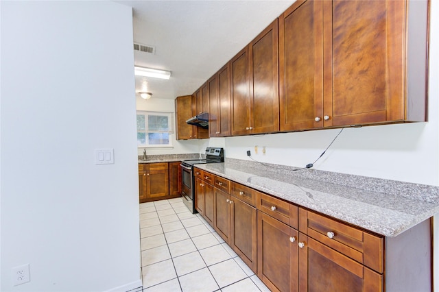 kitchen featuring light stone countertops, under cabinet range hood, stainless steel electric range oven, visible vents, and light tile patterned flooring