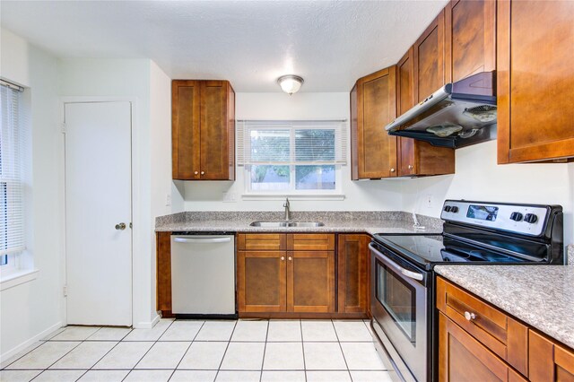 2215 Squire Dobbins Dr, Sugar Land, TX 77478 - kitchen with stainless steel appliances, a sink, under cabinet range hood, and light tile patterned floors