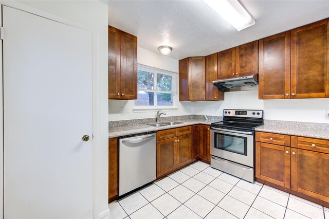 2215 Squire Dobbins Dr, Sugar Land, TX 77478 - kitchen featuring under cabinet range hood, stainless steel appliances, a sink, and light tile patterned floors