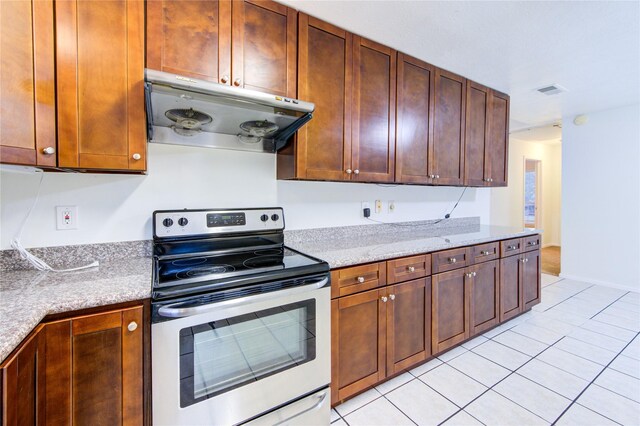 2215 Squire Dobbins Dr, Sugar Land, TX 77478 - kitchen featuring electric range, under cabinet range hood, light tile patterned flooring, and light stone counters