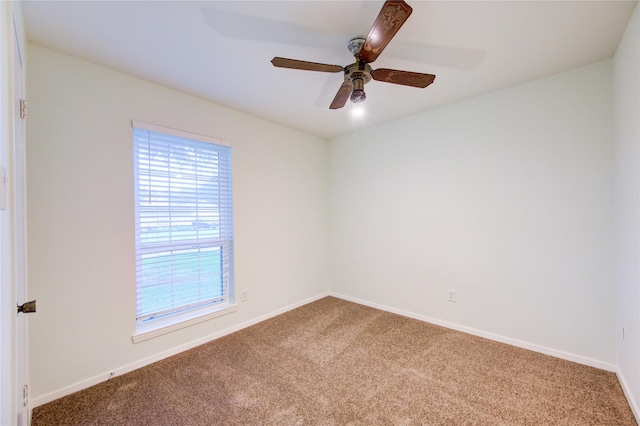 carpeted spare room featuring baseboards and ceiling fan