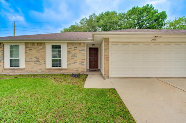 single story home with an attached garage, roof with shingles, a front yard, brick siding, and driveway