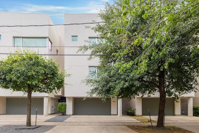 view of property featuring concrete driveway and a garage