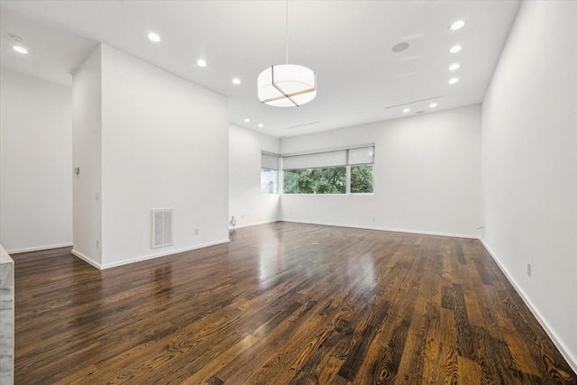empty room featuring recessed lighting, baseboards, visible vents, and wood finished floors