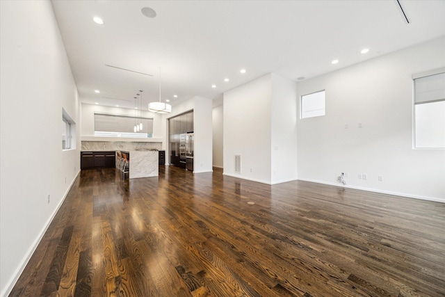 unfurnished living room with recessed lighting, baseboards, visible vents, and dark wood finished floors
