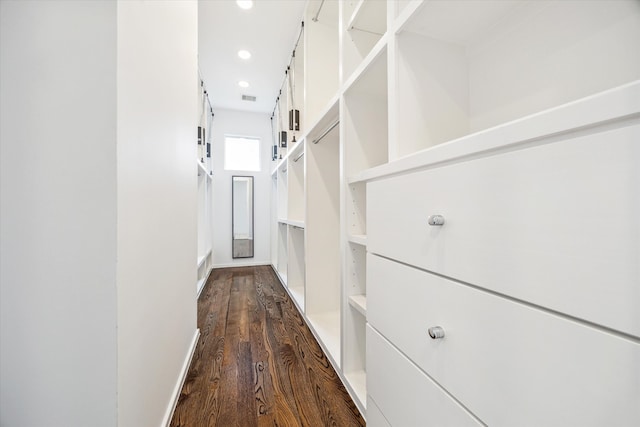 hallway with a barn door, dark wood-type flooring, visible vents, and recessed lighting