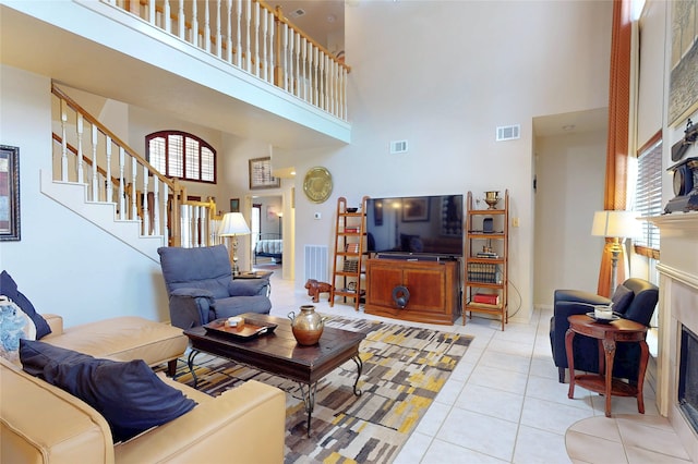 12934 Bristol Berry Dr, Cypress, TX 77429 - living room with a high ceiling, a fireplace, light tile patterned flooring, and stairs