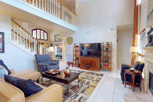 12934 Bristol Berry Dr, Cypress, TX 77429 - living room featuring a towering ceiling, a fireplace, light tile patterned floors, and stairway