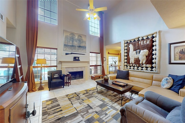 12934 Bristol Berry Dr, Cypress, TX 77429 - living room with a towering ceiling, tile patterned floors, a ceiling fan, and a tiled fireplace