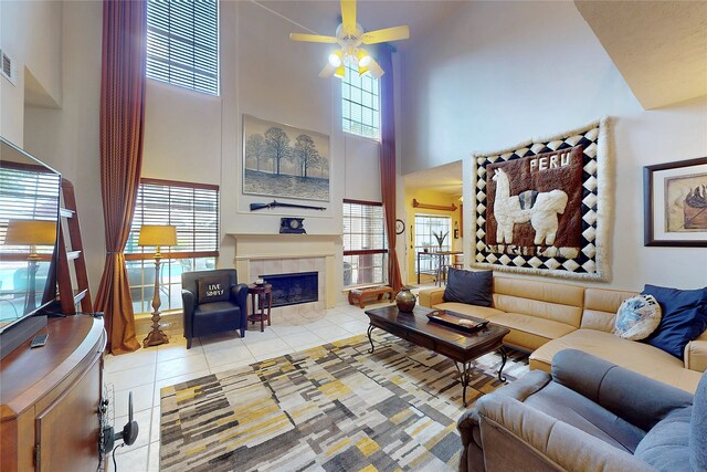 12934 Bristol Berry Dr, Cypress, TX 77429 - living room featuring a high ceiling, tile patterned floors, a ceiling fan, and a tile fireplace