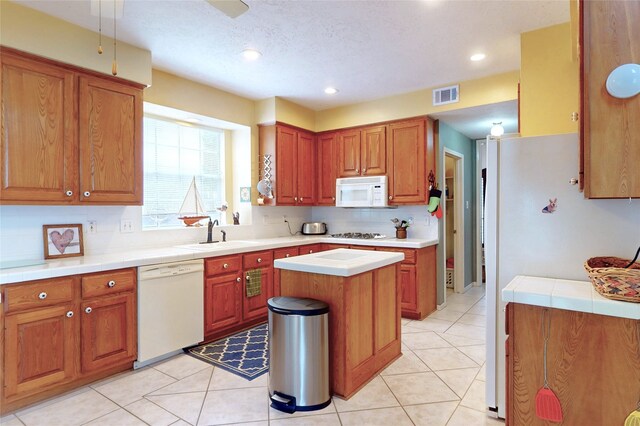 12934 Bristol Berry Dr, Cypress, TX 77429 - kitchen featuring white appliances, a sink, brown cabinetry, recessed lighting, and tasteful backsplash