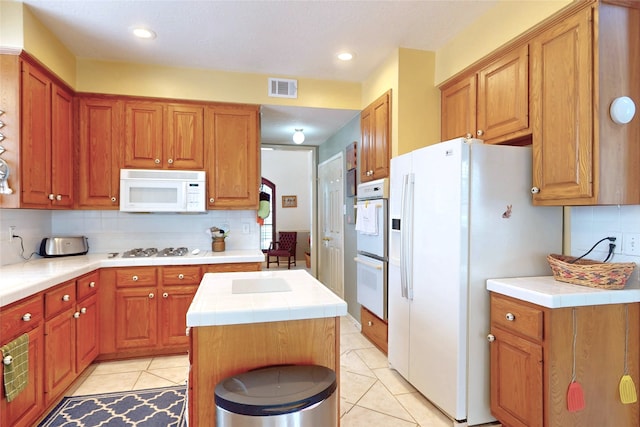 12934 Bristol Berry Dr, Cypress, TX 77429 - kitchen with white appliances, tile counters, backsplash, light tile patterned floors, and recessed lighting