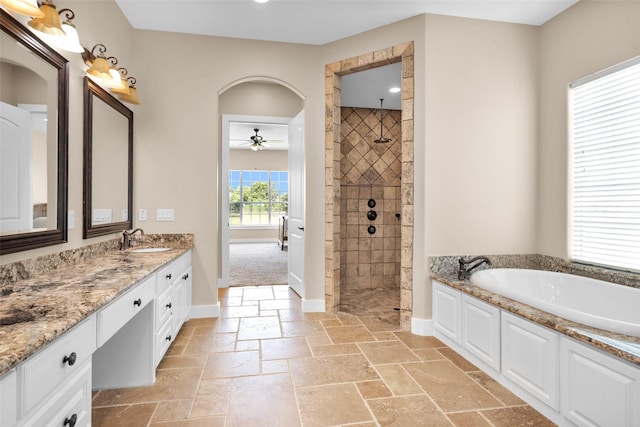 1650 Winding Canyon Ct, Katy, TX 77493 - full bathroom featuring a ceiling fan, a tile shower, stone tile floors, a bath, and vanity