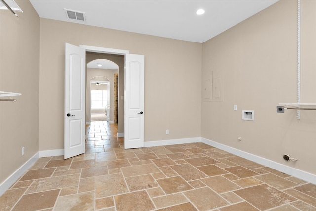 1650 Winding Canyon Ct, Katy, TX 77493 - washroom with stone tile floors, hookup for a gas dryer, electric dryer hookup, washer hookup, and baseboards