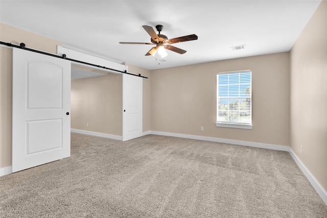 1650 Winding Canyon Ct, Katy, TX 77493 - empty room with a ceiling fan, a barn door, baseboards, visible vents, and light colored carpet