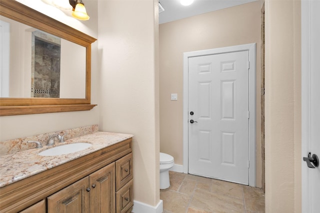 1650 Winding Canyon Ct, Katy, TX 77493 - bathroom featuring toilet, baseboards, vanity, and stone tile flooring