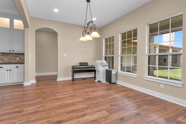 1650 Winding Canyon Ct, Katy, TX 77493 - unfurnished dining area featuring wood finished floors, baseboards, and arched walkways