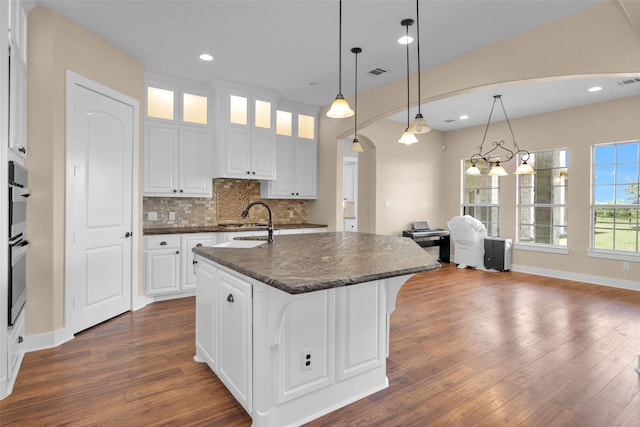 1650 Winding Canyon Ct, Katy, TX 77493 - kitchen with a sink, dark countertops, dark wood-type flooring, visible vents, and backsplash