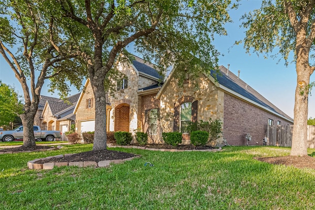 traditional home with stone siding, brick siding, and a front yard