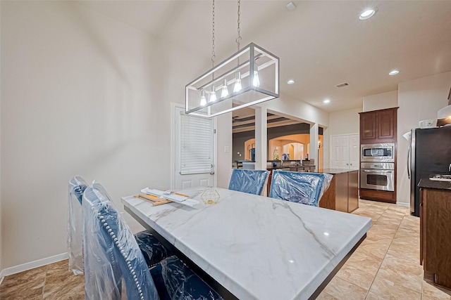 dining room featuring visible vents, baseboards, arched walkways, and recessed lighting