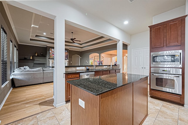 kitchen featuring dark stone countertops, crown molding, ceiling fan, arched walkways, and appliances with stainless steel finishes