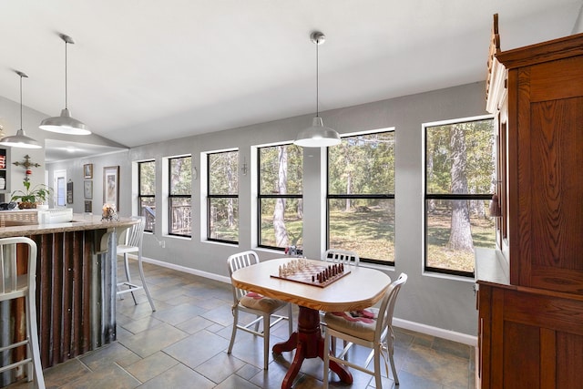 2540 Howell Rd, Corrigan, TX 75939 - dining space with baseboards, a wealth of natural light, vaulted ceiling, and stone tile flooring