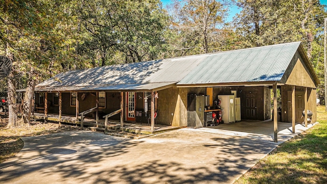 2540 Howell Rd, Corrigan, TX 75939 - view of front of home with metal roof, covered porch, driveway, and a carport