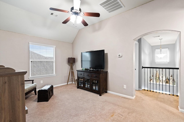 living area with carpet flooring, visible vents, ceiling fan, and arched walkways