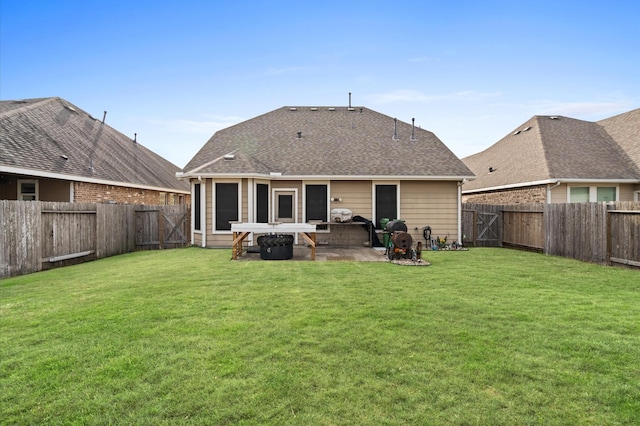 rear view of house featuring a lawn, a patio area, and a fenced backyard