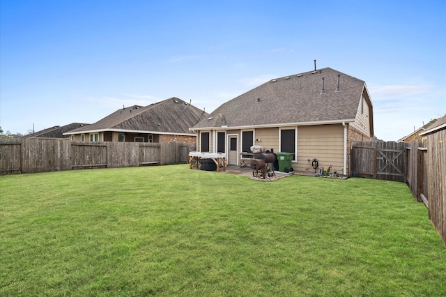 rear view of house featuring a fenced backyard, roof with shingles, a patio area, and a lawn