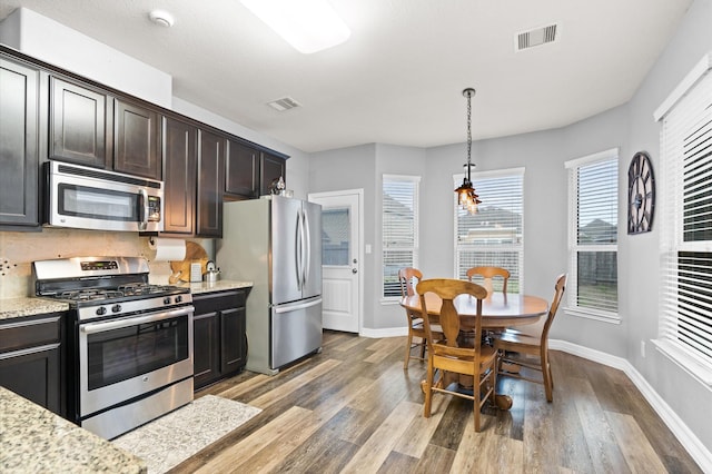kitchen with baseboards, light wood-type flooring, visible vents, and appliances with stainless steel finishes