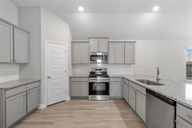 13714 Seneca Lake Dr, Texas City, TX 77568 - kitchen with a sink, lofted ceiling, stainless steel appliances, and gray cabinets