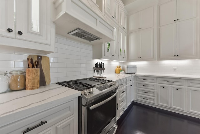 kitchen with premium range hood, decorative backsplash, white cabinetry, and gas range