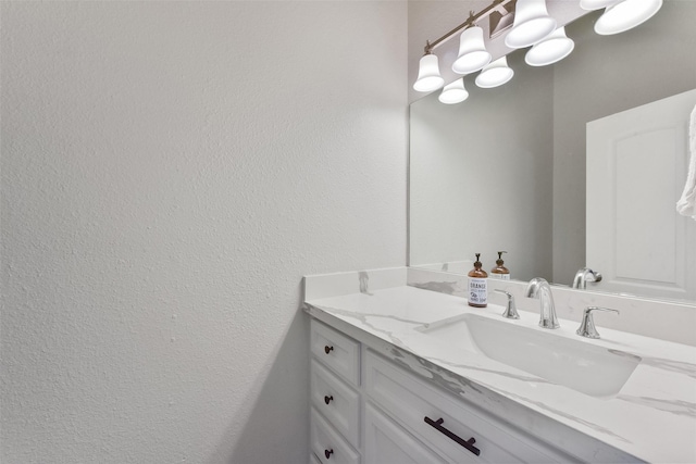 bathroom featuring vanity and a textured wall