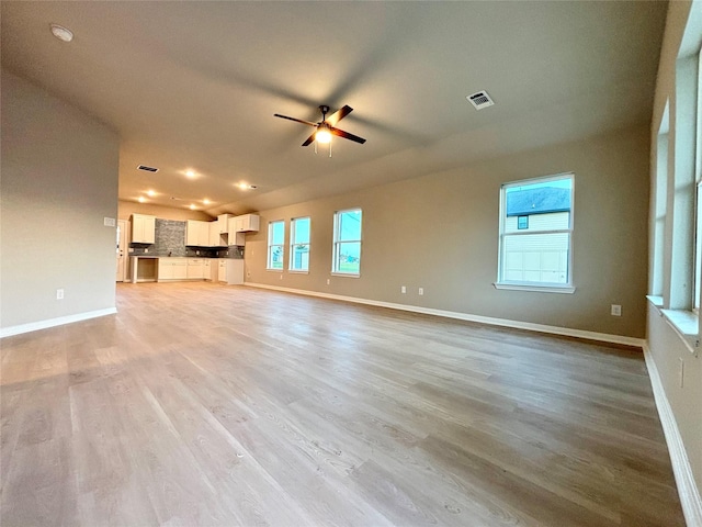 1105 W Bayshore Dr, Palacios, TX 77465 - unfurnished living room with light wood-type flooring, baseboards, a ceiling fan, and visible vents