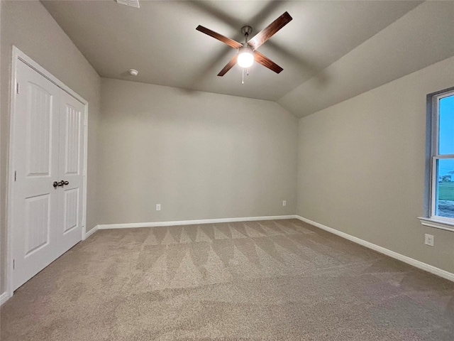 1105 W Bayshore Dr, Palacios, TX 77465 - unfurnished bedroom with carpet flooring, vaulted ceiling, baseboards, and ceiling fan