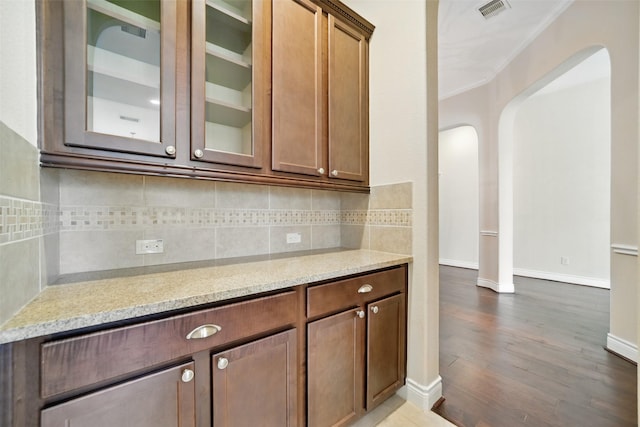 2106 Wild Peregrine Cir, Katy, TX 77494 - bar featuring arched walkways, backsplash, dark wood-style floors, baseboards, and ornamental molding