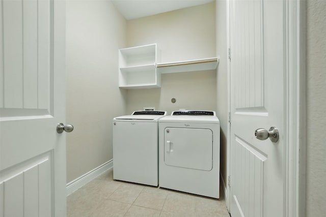 2106 Wild Peregrine Cir, Katy, TX 77494 - laundry room featuring washing machine and clothes dryer, light tile patterned flooring, and baseboards