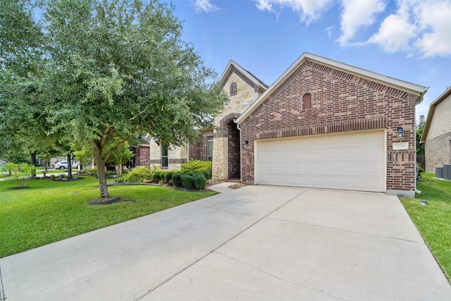 2106 Wild Peregrine Cir, Katy, TX 77494 - view of front of house with brick siding, an attached garage, driveway, a front lawn, and cooling unit