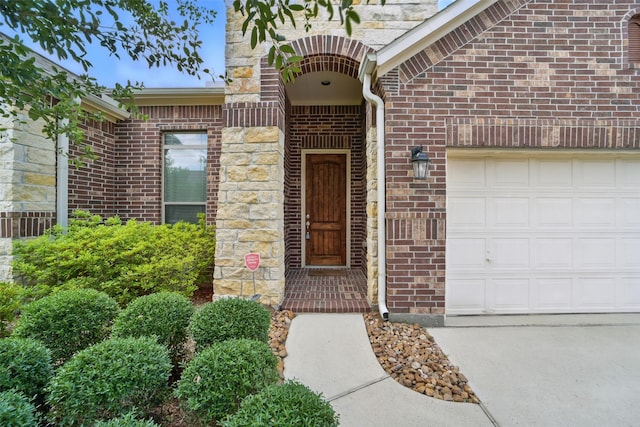 2106 Wild Peregrine Cir, Katy, TX 77494 - property entrance with an attached garage, brick siding, stone siding, and driveway