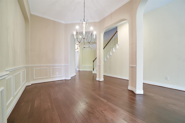 2106 Wild Peregrine Cir, Katy, TX 77494 - unfurnished dining area with a chandelier, arched walkways, dark wood finished floors, crown molding, and stairs