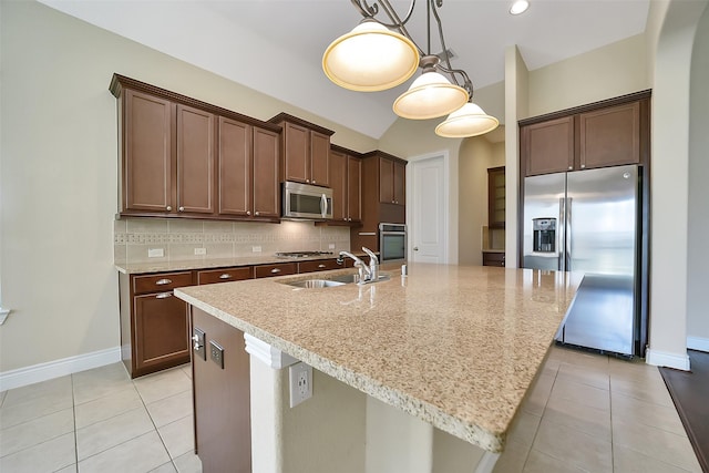 2106 Wild Peregrine Cir, Katy, TX 77494 - kitchen featuring appliances with stainless steel finishes, light tile patterned floors, backsplash, a center island with sink, and vaulted ceiling